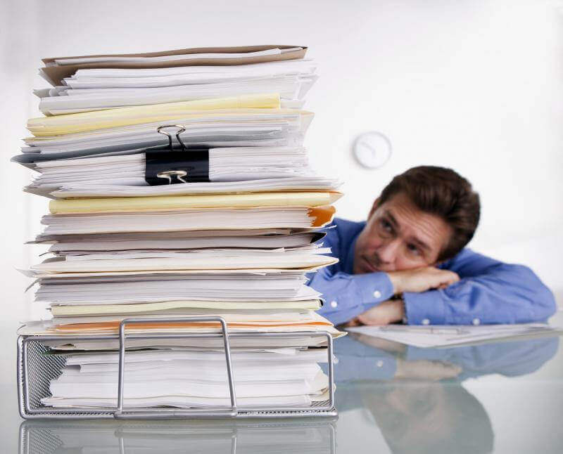 Man staring at stacks of files where ATS Accounting and Tax Edmonton can help